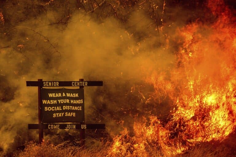Wildfires with sign saying water a mask